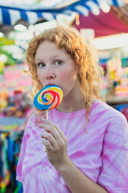 Medium shot cute girl eating lollipop