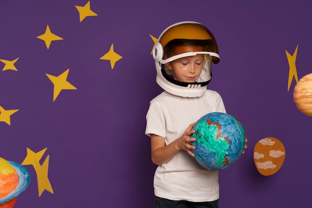 Free Photo medium shot cute kid holding planet