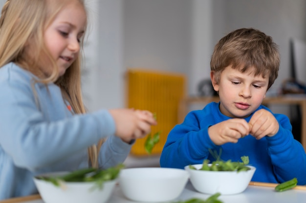 Free photo medium shot cute kids with food on table