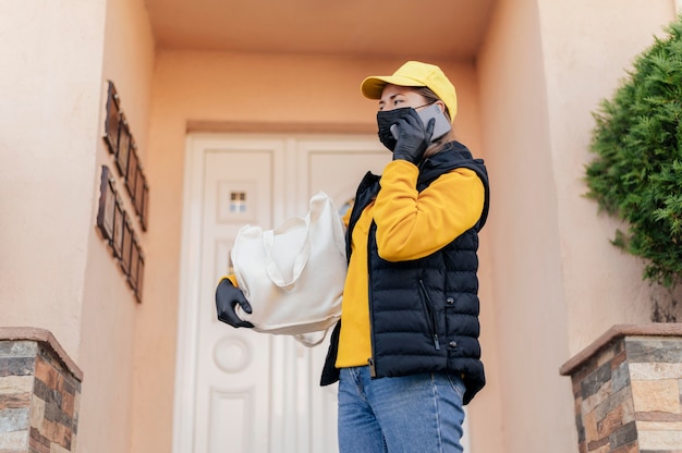 Medium shot delivery woman at door