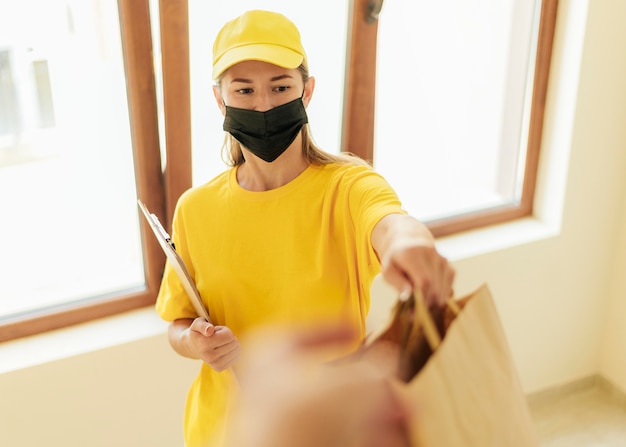 Free photo medium shot delivery woman holding bags