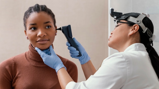 Medium shot doctor checking patient ears