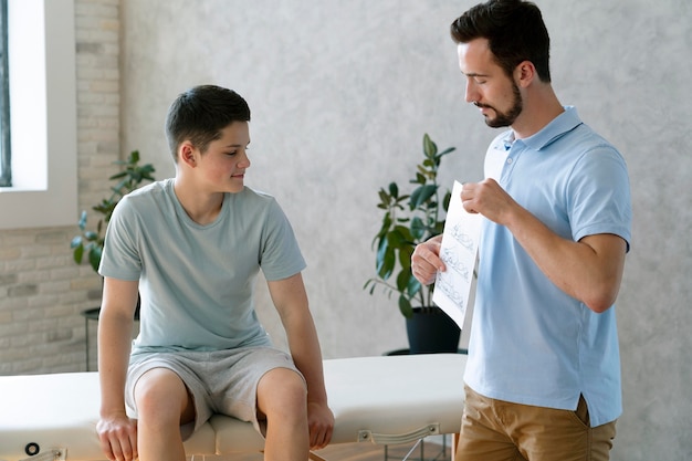 Free photo medium shot doctor explaining to boy