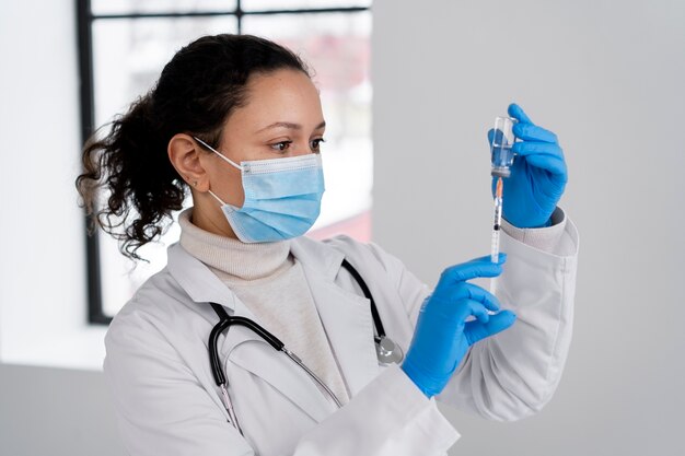 Medium shot doctor holding syringe and vial