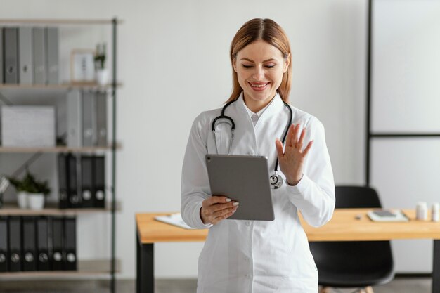 Medium shot doctor holding tablet