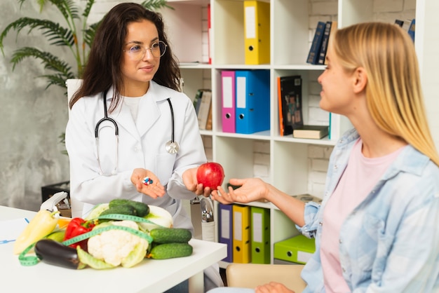 Medium shot doctor and patient with fruits