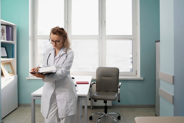 Free photo medium shot doctor taking notes at clinic