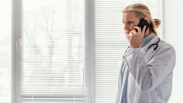 Free Photo medium shot doctor talking on phone