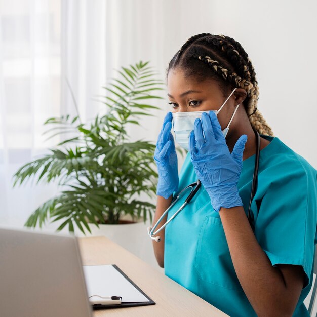 Medium shot doctor wearing mask and gloves