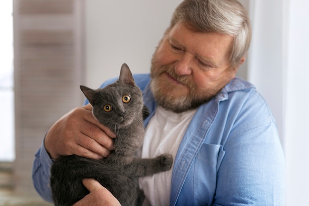 Free Photo medium shot elderly man with cat