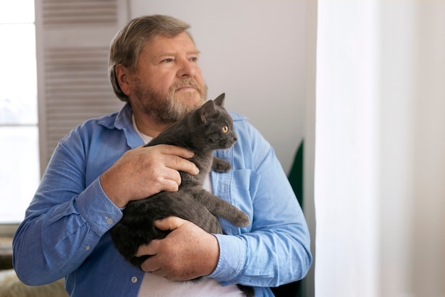 Free Photo medium shot elderly man with cat