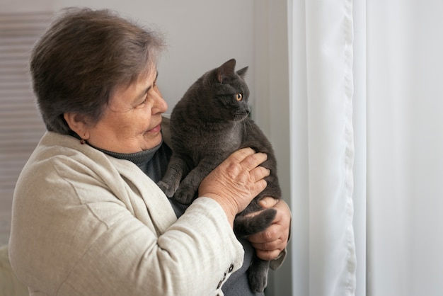 Free photo medium shot elderly woman with cat