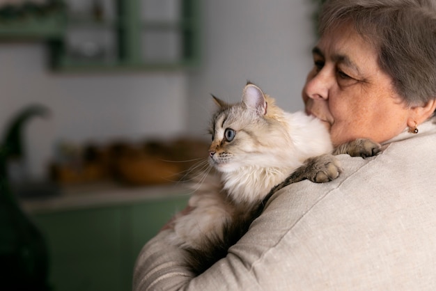 Medium shot elderly woman with cat