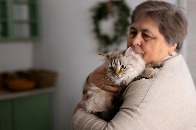 Free photo medium shot elderly woman with cat