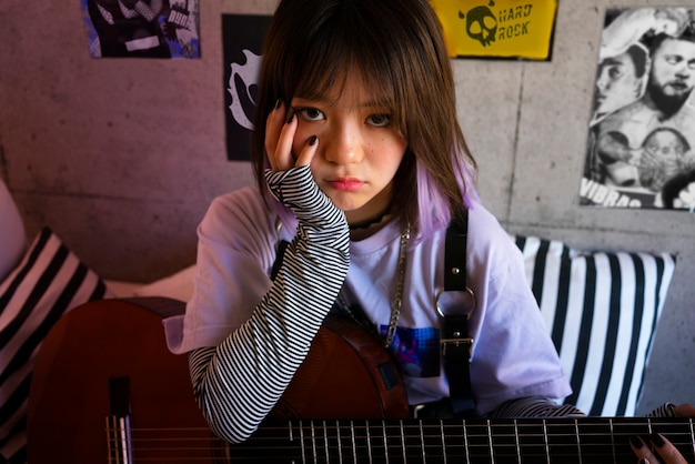 Free photo medium shot emo girl holding guitar