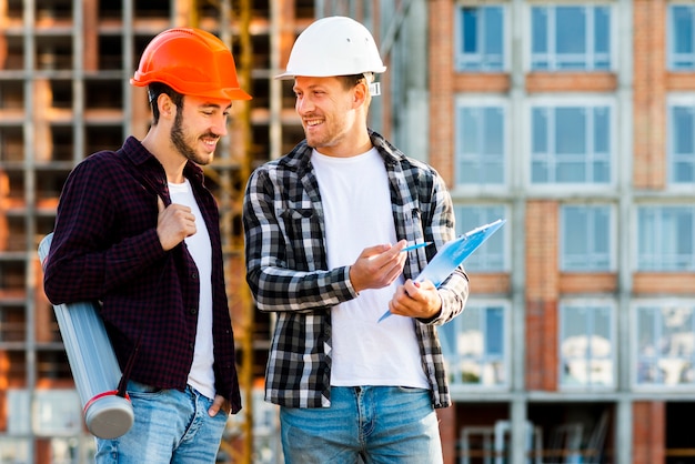 Free photo medium shot of engineer and architect  looking at clipboard