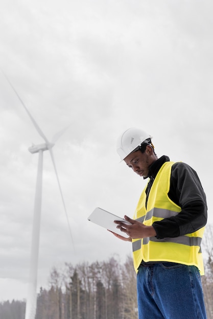 Free Photo medium shot engineer holding tablet outdoors