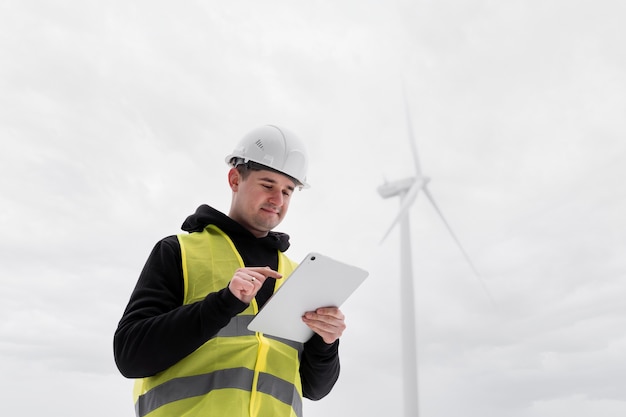 Medium shot engineer holding tablet outside