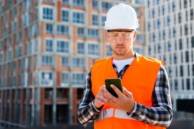 Free photo medium shot of engineer looking at phone