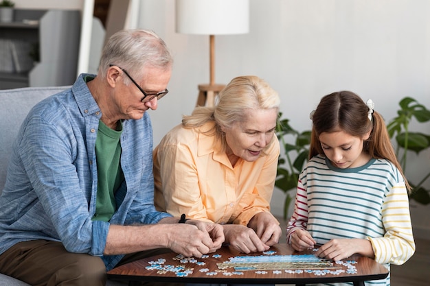 Free photo medium shot family doing puzzle together