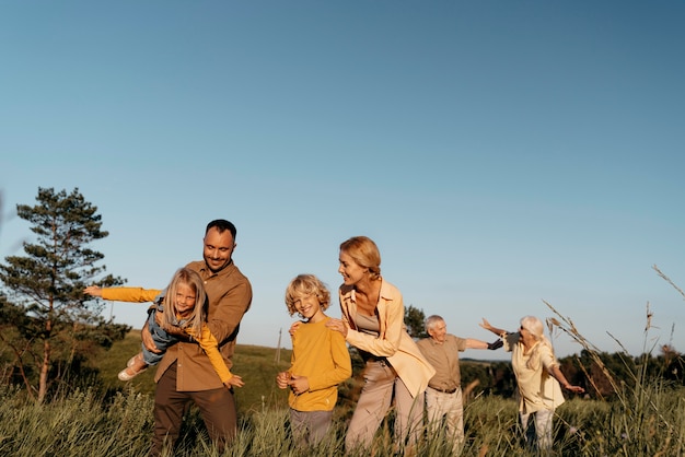 Medium shot family having fun on meadow