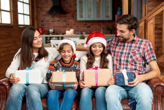 Medium shot family members with gifts on the couch