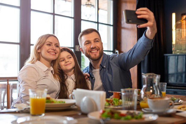 Medium shot family taking selfie