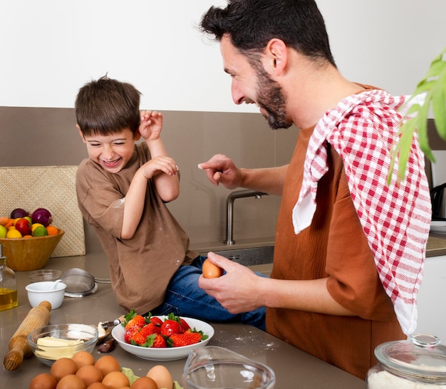 Medium shot father and boy cooking together