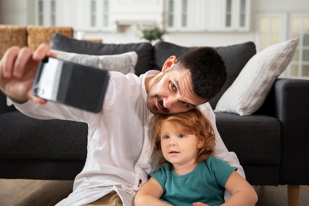 Medium shot father and kid taking selfie