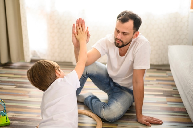 Free photo medium shot father and son high five