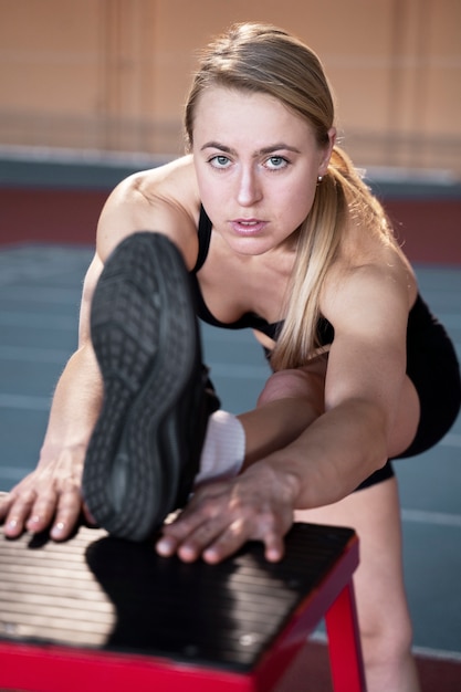 Medium shot fit woman stretching leg