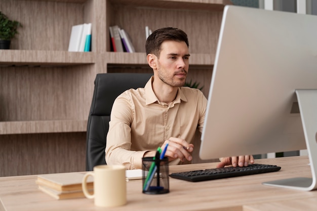 Free photo medium shot focused man working on computer