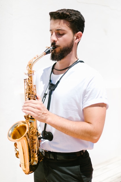 Free photo medium shot focused musician playing the sax