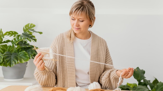 Free photo medium shot focused woman knitting