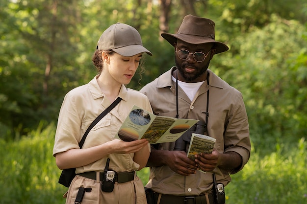 Free photo medium shot forest wardens with brochure