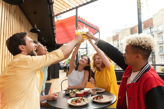 Free Photo medium shot friends clinking glasses