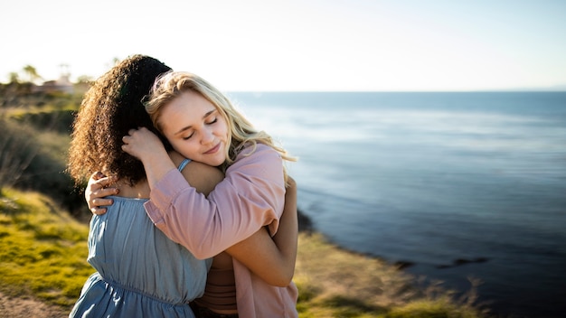 Medium shot friends hugging outdoors