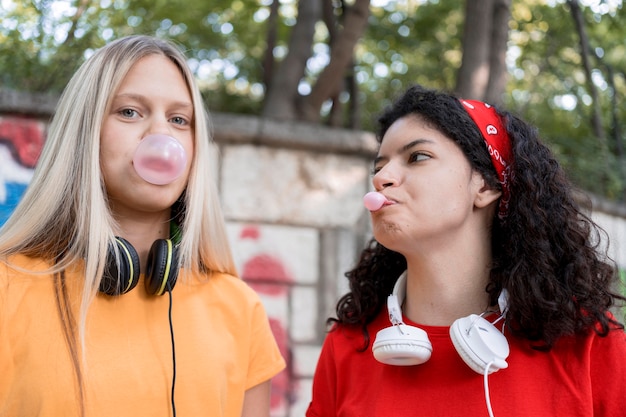 Free Photo medium shot friends making bubble gum