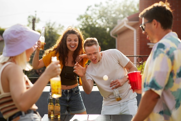 Medium shot friends playing beer pong