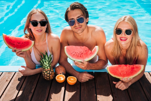 Free Photo medium shot friends in pool looking at camera