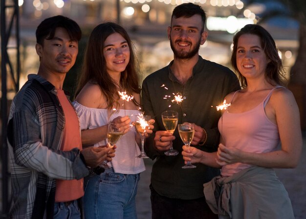 Medium shot friends posing with fireworks