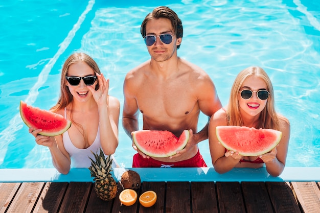 Medium shot friends posing with watermelon