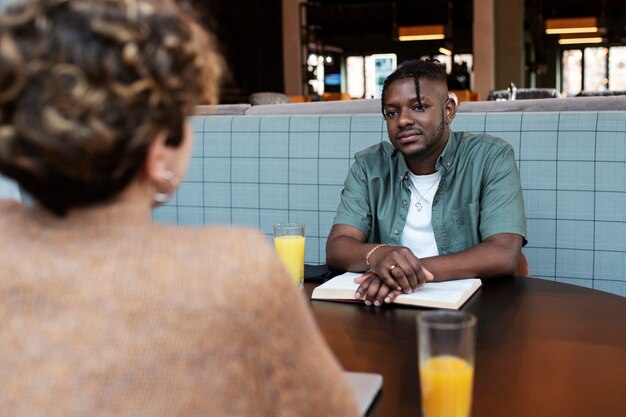 Medium shot friends sitting in coffee shop