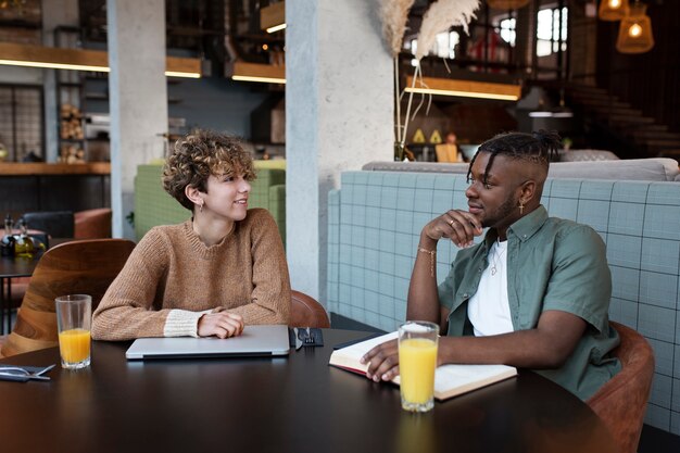 Medium shot friends sitting in coffee shop