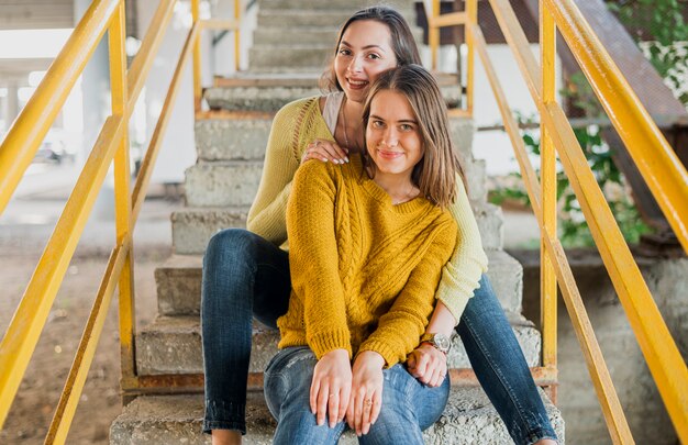 Medium shot friends sitting on the stairs