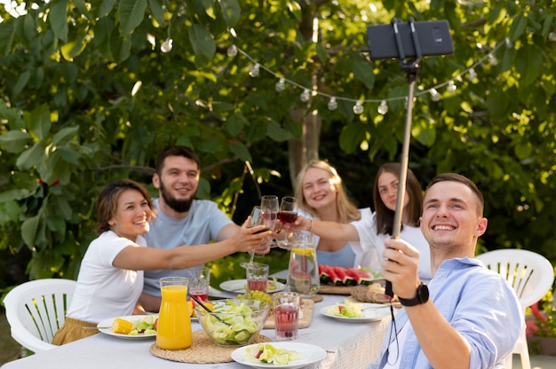 Medium shot friends taking selfie outdoors