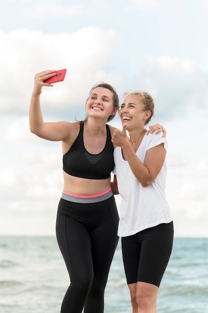 Medium shot friends taking selfie