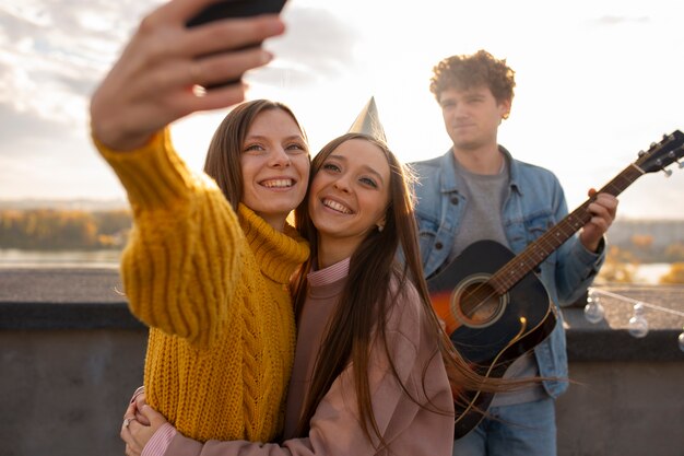 Medium shot friends taking selfie