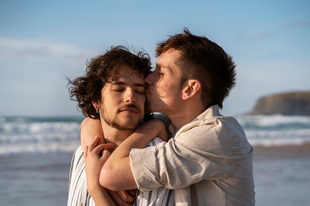 Medium shot gay couple at the beach