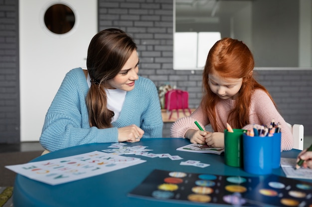 Medium shot girl coloring at table